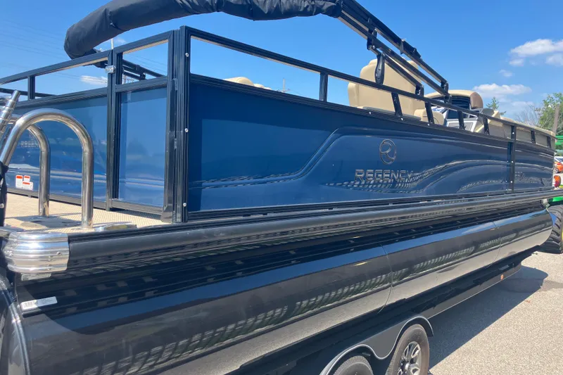Slide: The Image of 2025 Regency 250 DL3 pontoon boat with sleek blue exterior and stainless steel accents. - 6