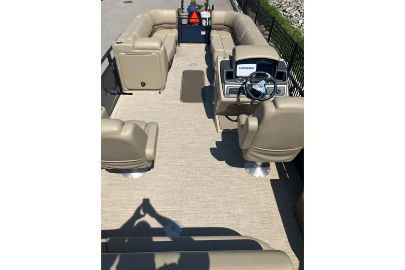 Slide: The Image of 2025 Regency 250 DL3 pontoon boat interior with beige seating and steering console. - 8
