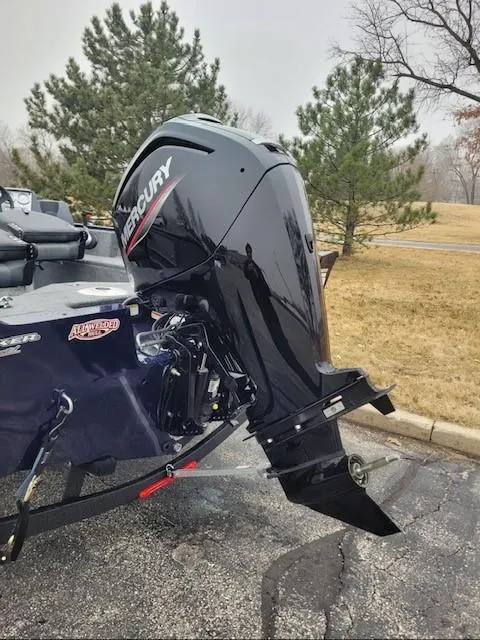 Slide: The Image of 2025 Tracker Pro Guide V-16 SC boat with Mercury outboard motor in a park setting. - 2