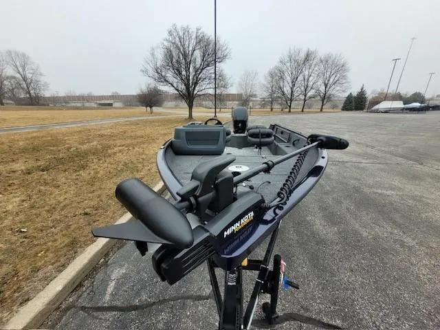 Slide: The Image of 2025 Tracker Pro Guide V-16 SC boat with Minn Kota trolling motor in a parking lot. - 5