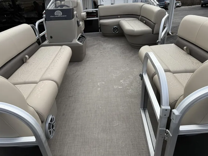 Slide: The Image of 2025 Sun Tracker Party Barge 16 DLX interior with beige seating and spacious layout. - 4