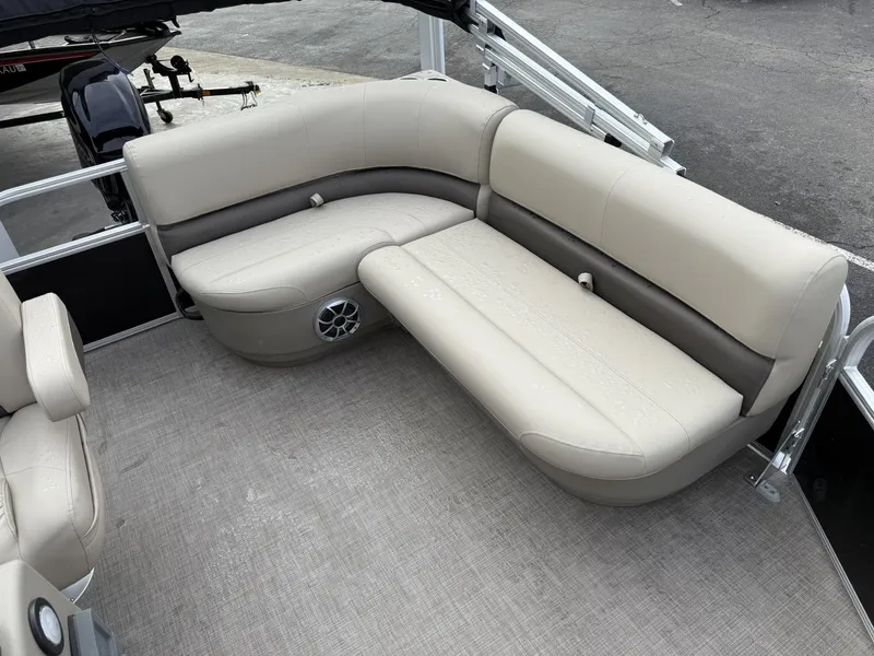 Slide: The Image of 2025 Sun Tracker Party Barge 16 DLX interior with beige seating and carpeted floor. - 7