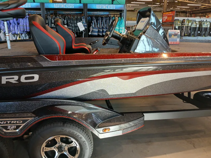 Slide: The Image of 2025 Nitro Z21 XL boat with sleek design and red-accented seats in showroom. - 15