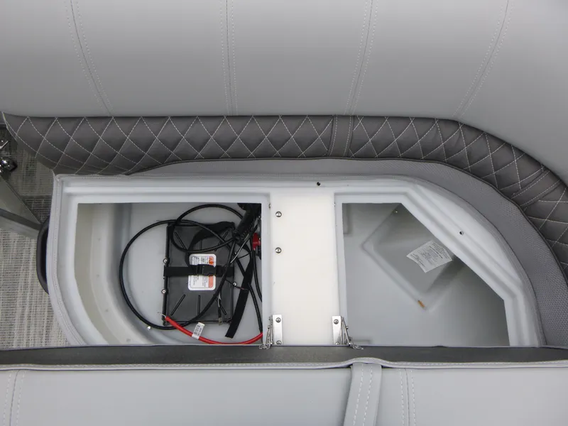 Slide: The Image of 2025 Ranger Reata 220C boat seat storage compartment with quilted upholstery and visible contents. - 9