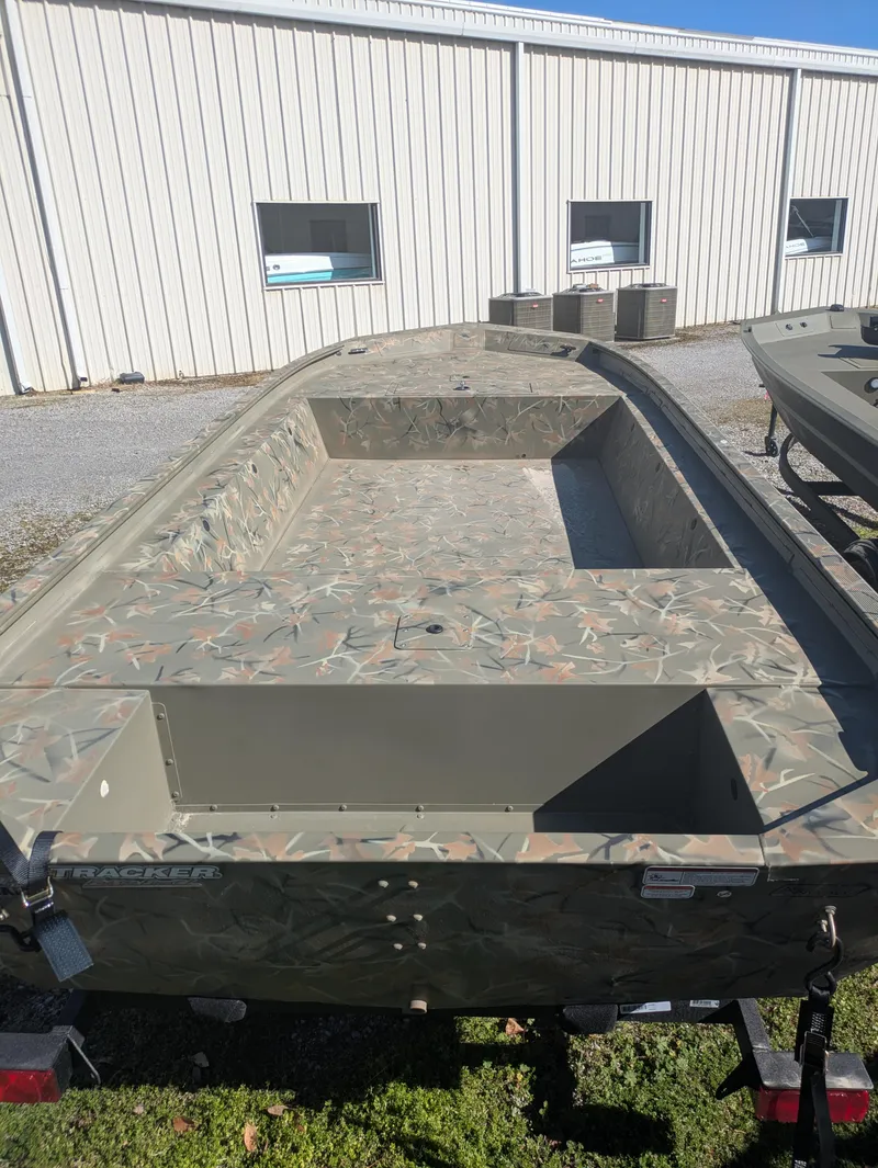Slide: The Image of 2025 Tracker Grizzly 1754 Jon boat with camouflage design, parked outdoors. - 2