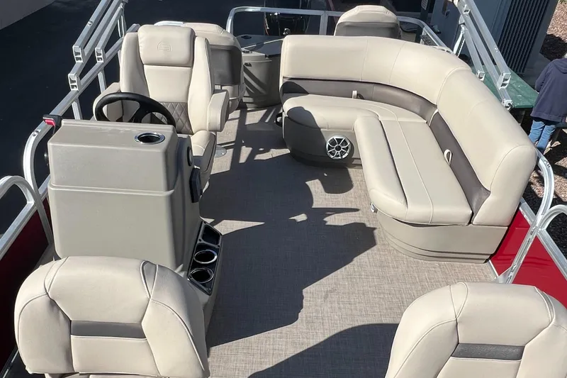 Slide: The Image of 2025 Sun Tracker Bass Buggy 18 DLX pontoon boat interior with beige seating and steering console. - 5
