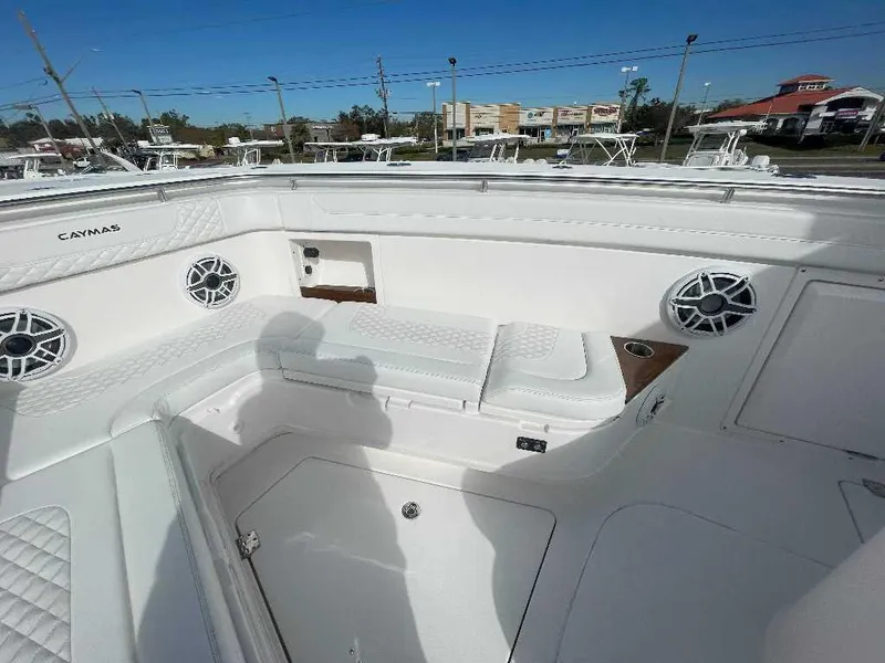 Slide: The Image of 2024 Caymas 401 CC boat interior with white seating and speakers. - 11