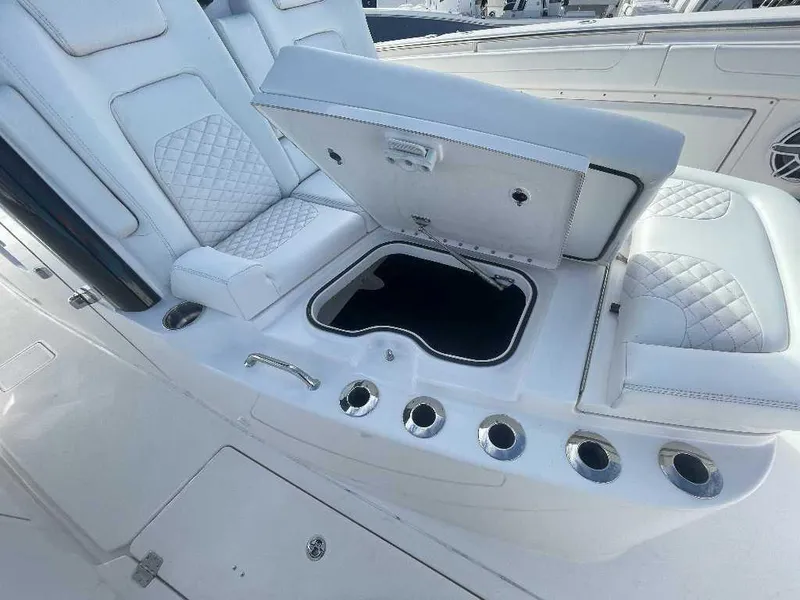 Slide: The Image of 2024 Caymas 401 CC boat interior with open storage compartment and cushioned seating. - 18