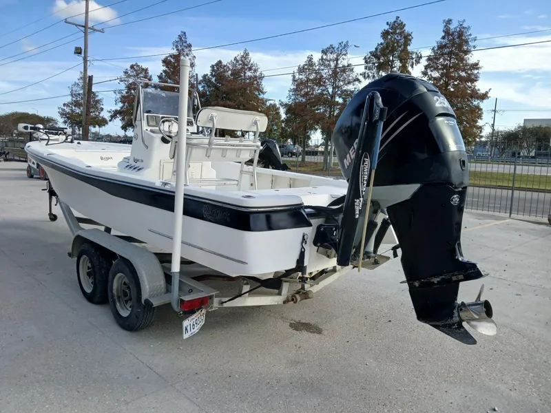 Slide: The Image of 2005 BlackJack 224 boat on trailer with outboard motor, parked outdoors. - 11