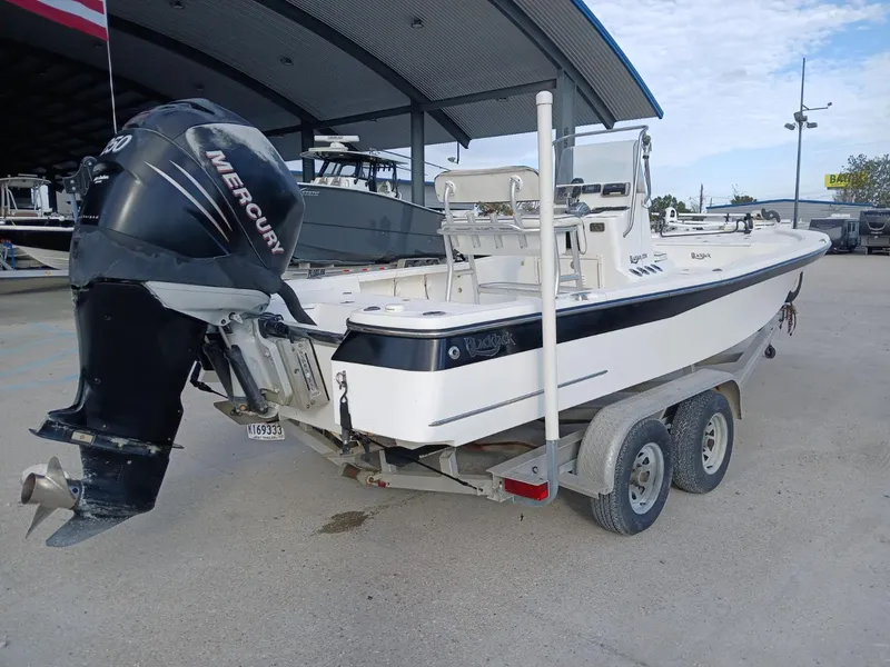 Slide: The Image of 2005 BlackJack 224 boat on trailer with Mercury outboard motor, parked under a canopy. - 12
