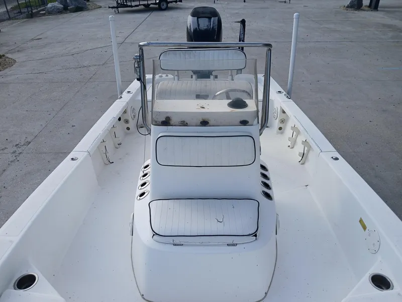Slide: The Image of 2005 BlackJack 224 boat interior with seating and console, parked on concrete surface. - 4