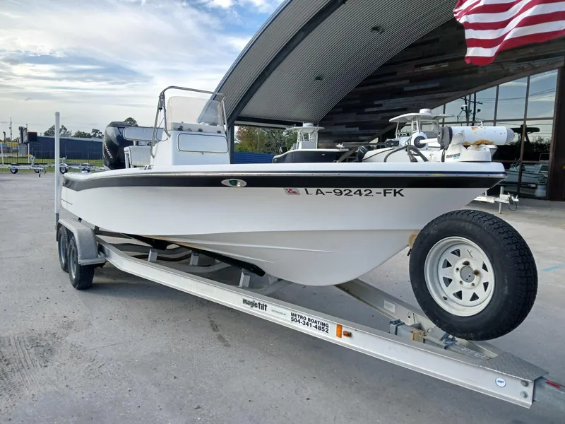 Slide: The Image of 2005 BlackJack 224 boat on trailer, parked outdoors, with American flag in background. - 9