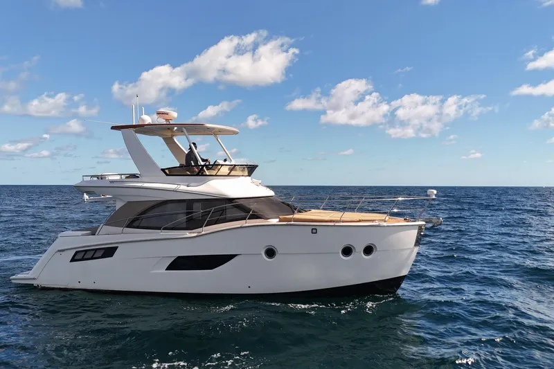 The Image of 2014 Carver 40 Command Bridge yacht cruising on open sea under blue sky. - 0