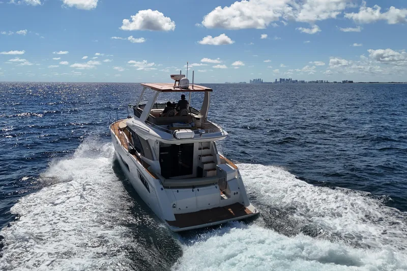 Slide: The Image of 2014 Carver 40 Command Bridge yacht cruising on open ocean under clear sky. - 10