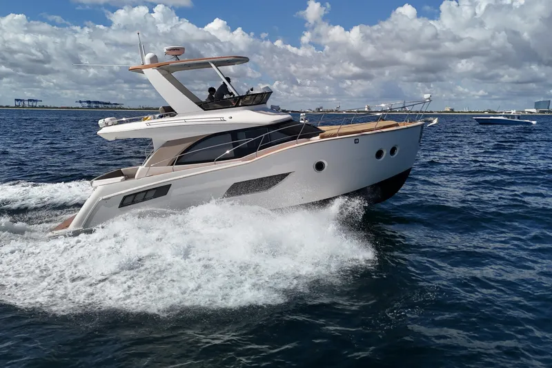 Slide: The Image of 2014 Carver 40 Command Bridge yacht cruising on open water under a cloudy sky. - 12