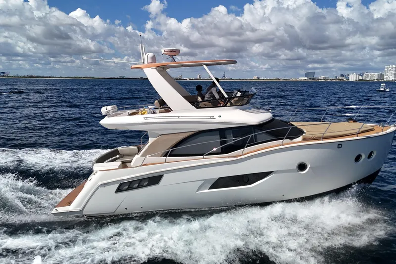 Slide: The Image of 2014 Carver 40 Command Bridge yacht cruising on open water under a cloudy sky. - 13