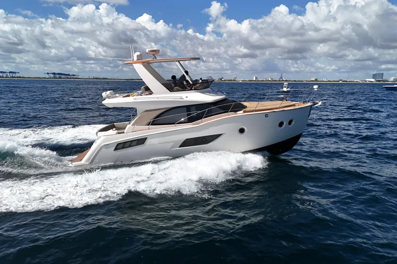 Slide: The Image of 2014 Carver 40 Command Bridge yacht cruising on open water under a cloudy sky. - 14