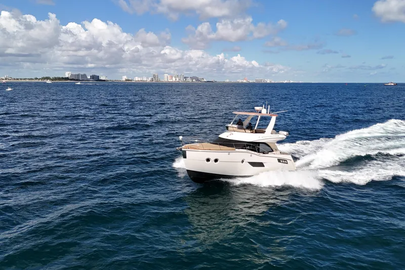 Slide: The Image of 2014 Carver 40 Command Bridge yacht cruising on open water under a clear sky. - 19
