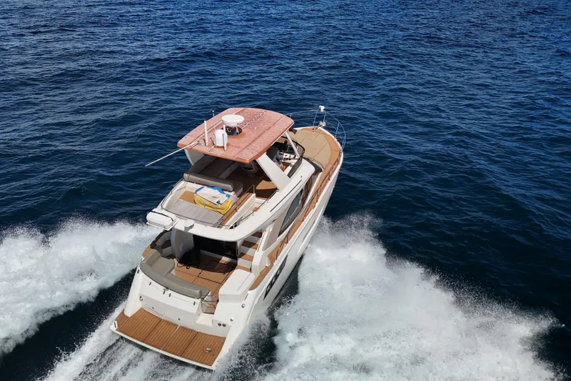 Slide: The Image of 2014 Carver 40 Command Bridge yacht cruising on open sea, aerial view. - 22