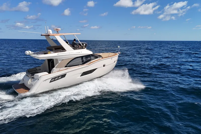 Slide: The Image of 2014 Carver 40 Command Bridge yacht cruising on open ocean under clear skies. - 7