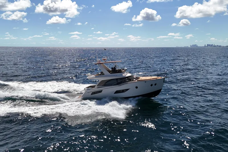 Slide: The Image of 2014 Carver 40 Command Bridge yacht cruising on open sea under blue sky. - 17