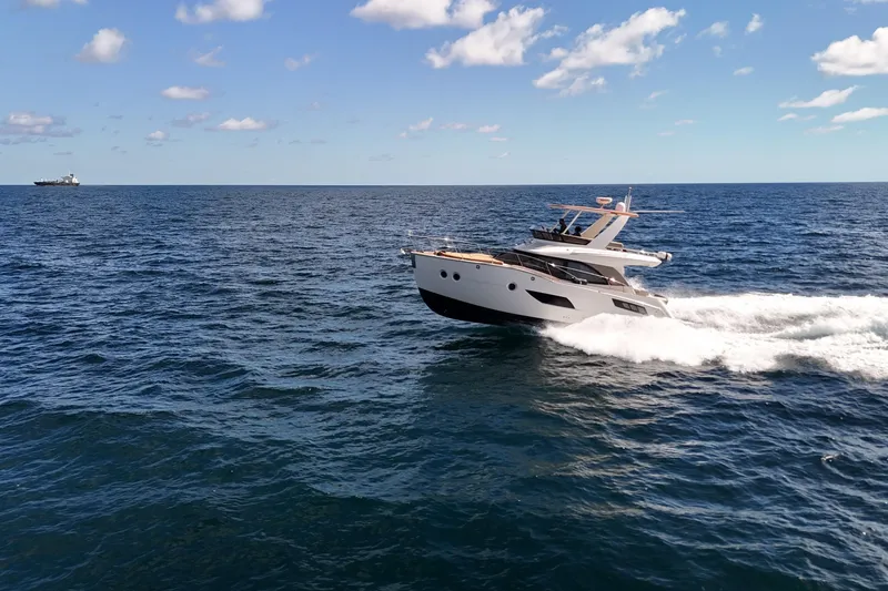 Slide: The Image of 2014 Carver 40 Command Bridge yacht cruising on open sea under blue sky. - 2