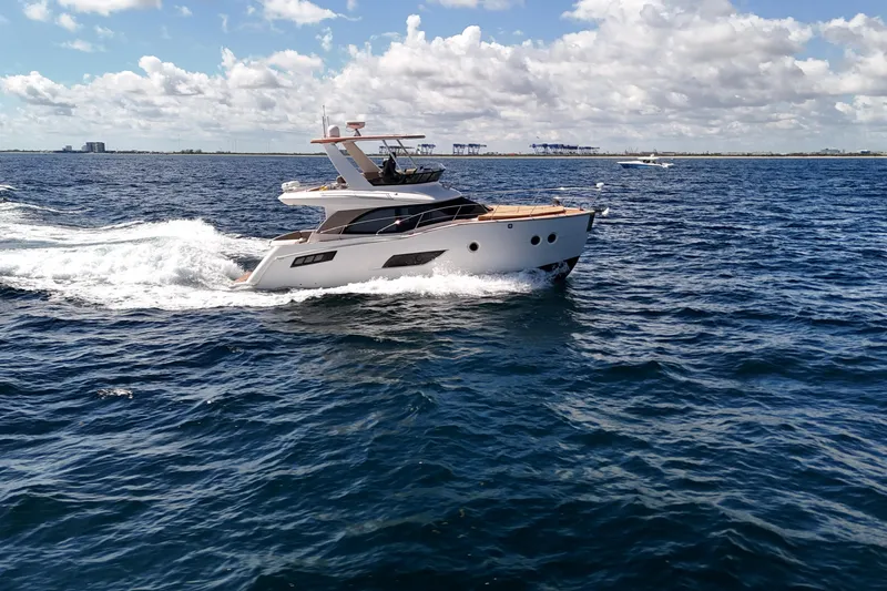 Slide: The Image of 2014 Carver 40 Command Bridge yacht cruising on open water under a partly cloudy sky. - 23