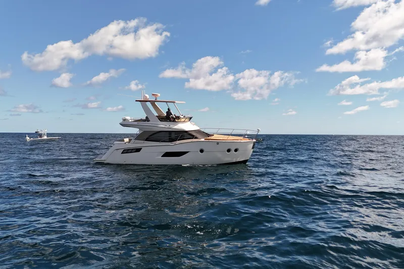 Slide: The Image of 2014 Carver 40 Command Bridge yacht cruising on open sea under blue sky. - 4