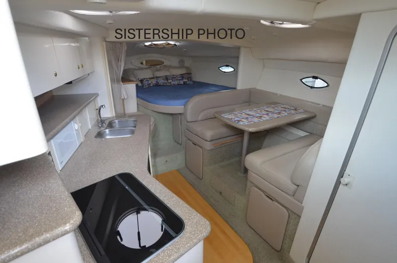 Slide: The Image of 1999 Maxum 3300 SCR cabin interior with kitchenette, dining area, and bed. - 11