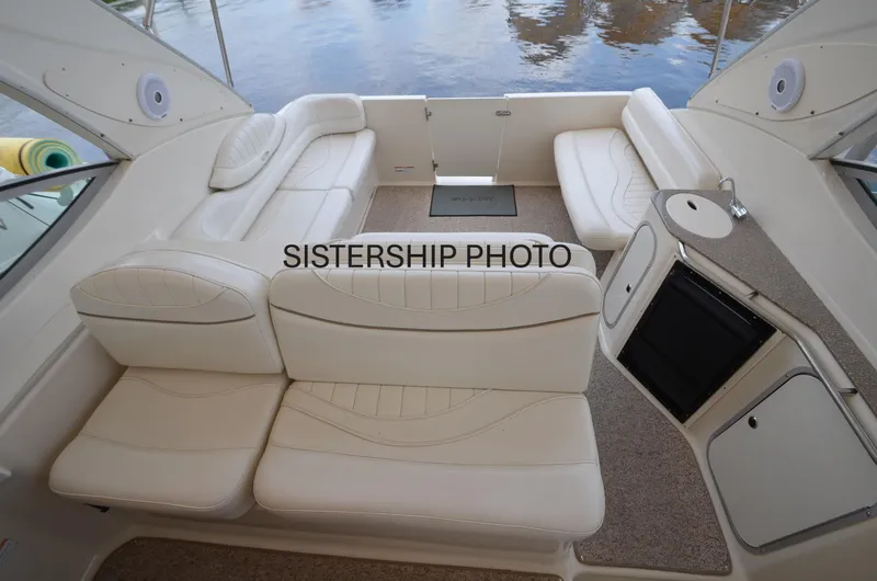 Slide: The Image of 1999 Maxum 3300 SCR boat interior with white seating and compact kitchenette. - 8
