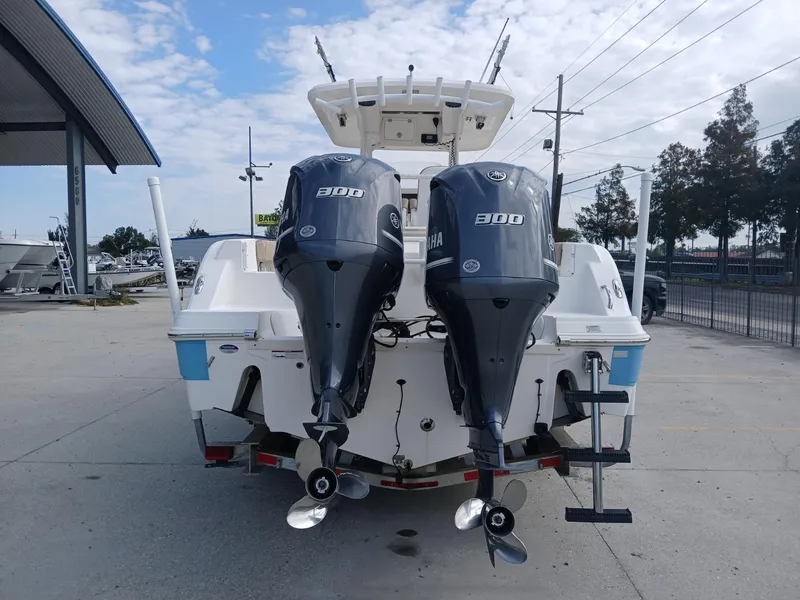Slide: The Image of 2015 Sea Fox 286 Commander boat with dual Yamaha 300 engines, parked outdoors. - 14