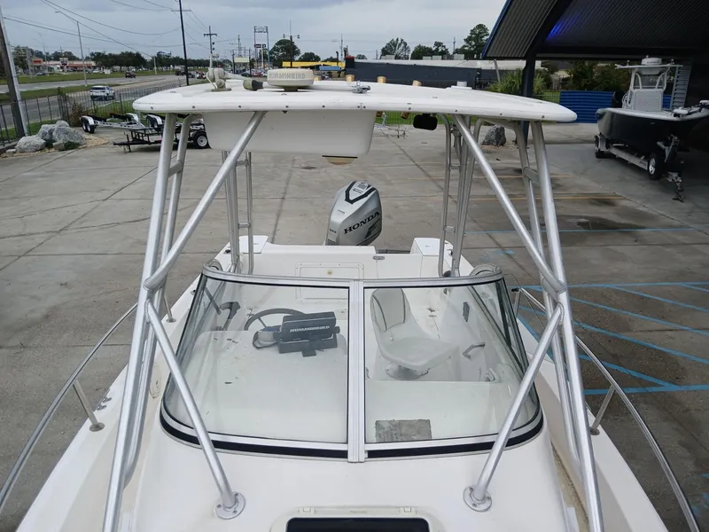 Slide: The Image of 1999 Century 2300 boat with Honda outboard motor, parked in a marina. - 2