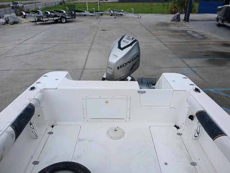 Slide: The Image of 1999 Century 2300 boat with Honda outboard motor in a parking area. - 4