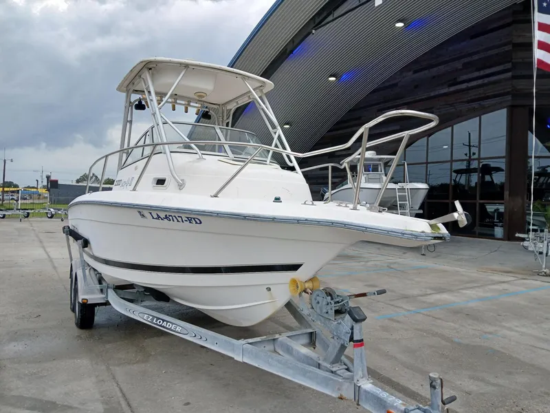 Slide: The Image of 1999 Century 2300 boat on trailer, parked outside a modern building. - 5