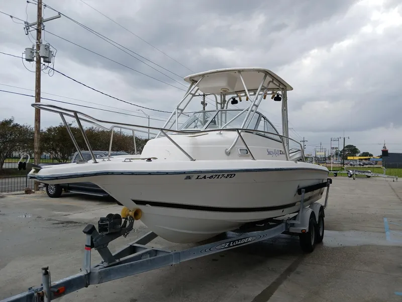 Slide: The Image of 1999 Century 2300 boat on trailer under cloudy sky. - 6