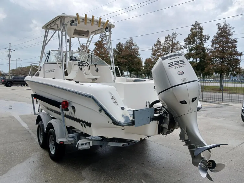 Slide: The Image of 1999 Century 2300 boat with Yamaha 225 engine on trailer, parked outdoors. - 7
