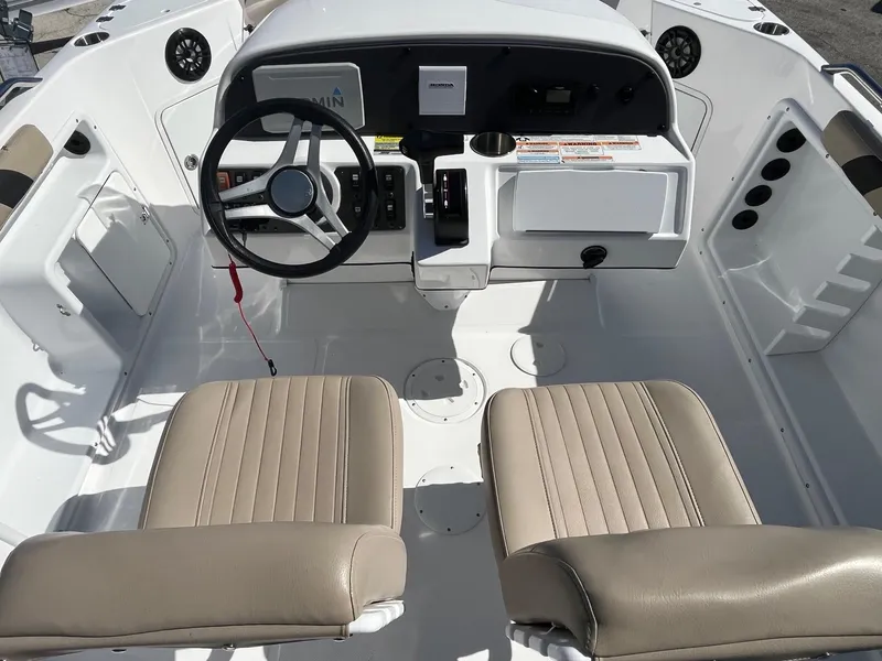 Slide: The Image of 2022 Hurricane Center Console SS 231 OB boat interior with steering wheel and beige seats. - 4
