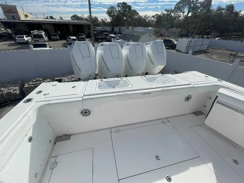 Slide: The Image of 2024 Caymas 401 CC boat with four Mercury outboard engines, docked in a marina. - 1