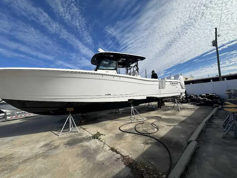 Slide: The Image of 2024 Caymas 401 CC boat on stands under a blue sky. - 6