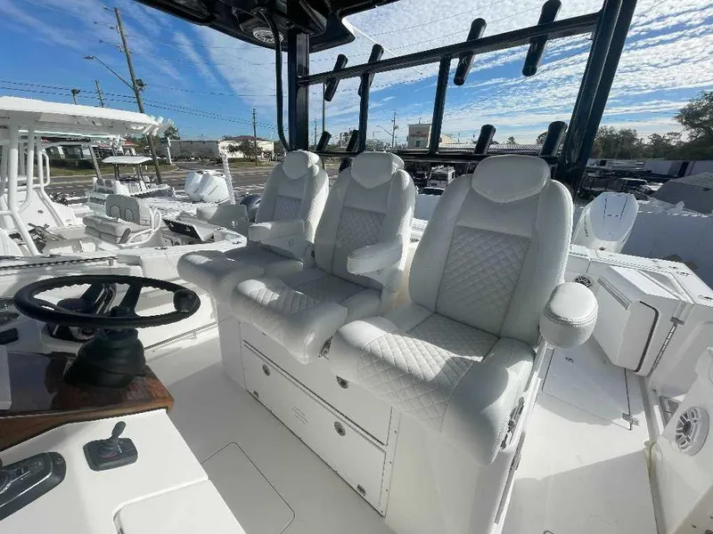 Slide: The Image of 2024 Caymas 401 CC boat interior with luxurious white seating and steering wheel. - 8