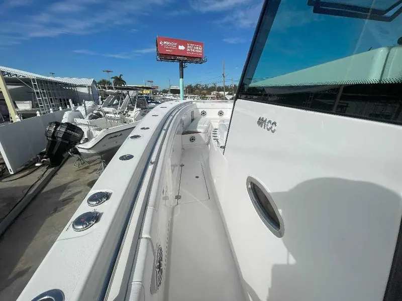 Slide: The Image of 2024 Caymas 401 CC boat displayed at a marina under clear blue skies. - 9