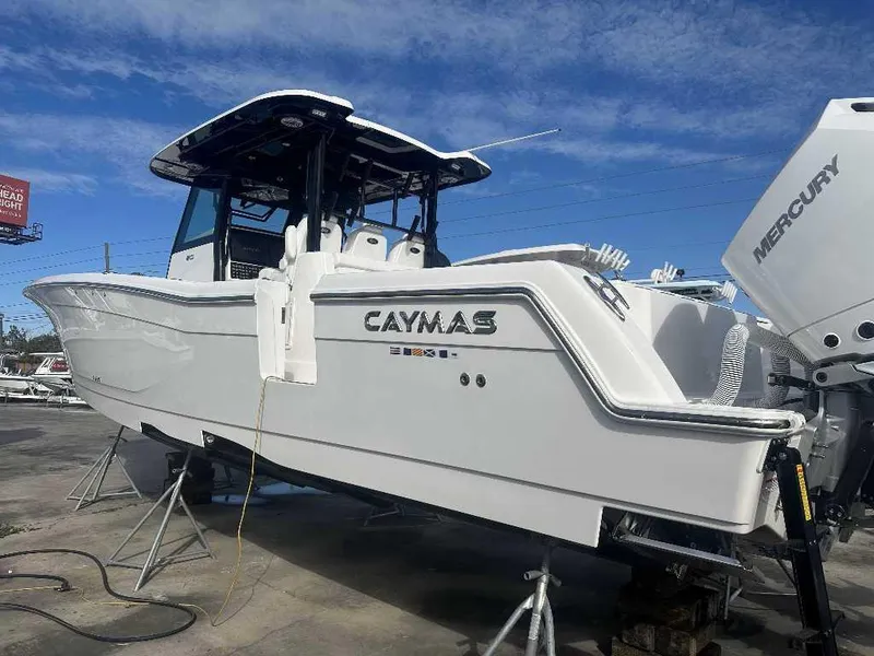 Slide: The Image of 2024 Caymas 401 CC boat with Mercury engines, displayed outdoors under a clear blue sky. - 5
