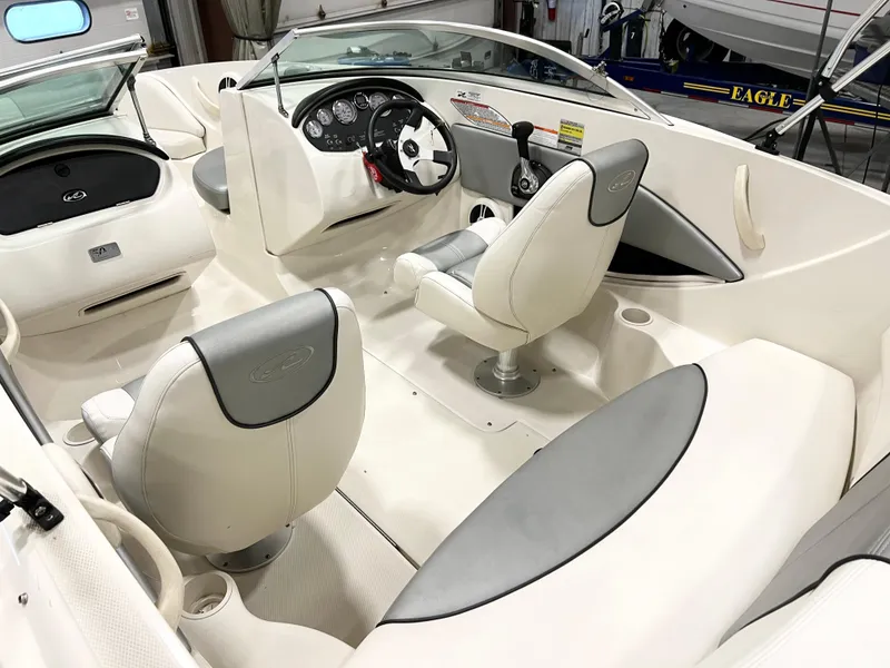 Slide: The Image of 2009 Sea Ray 185 Sport boat interior with white and gray seating, steering wheel, and dashboard. - 3