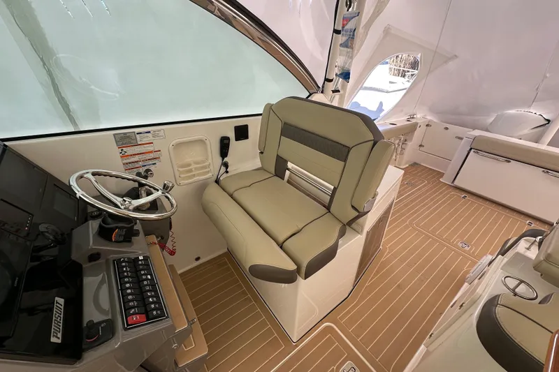 Slide: The Image of 2019 Pursuit DC 325 Dual Console interior with helm seat and modern dashboard. - 20