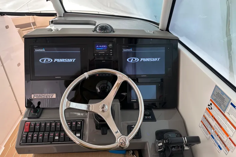 Slide: The Image of 2019 Pursuit DC 325 Dual Console helm with dual displays and steering wheel. - 25