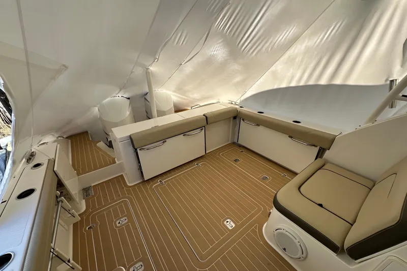 Slide: The Image of 2019 Pursuit DC 325 Dual Console interior with beige seating and wood-patterned flooring. - 3