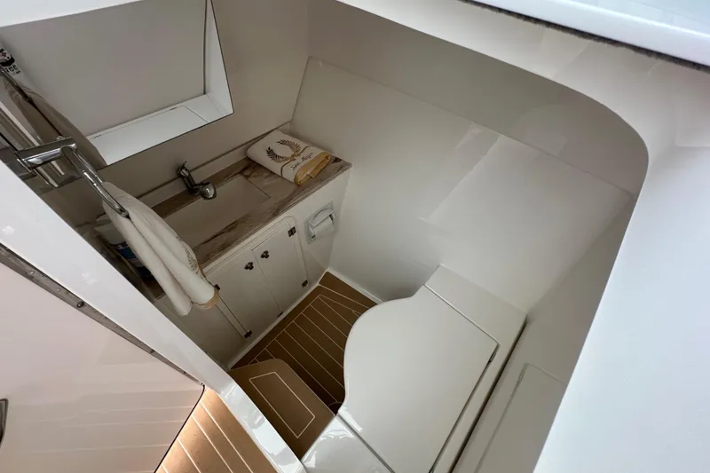 Slide: The Image of 2019 Pursuit DC 325 Dual Console boat interior with sink and wooden flooring. - 33