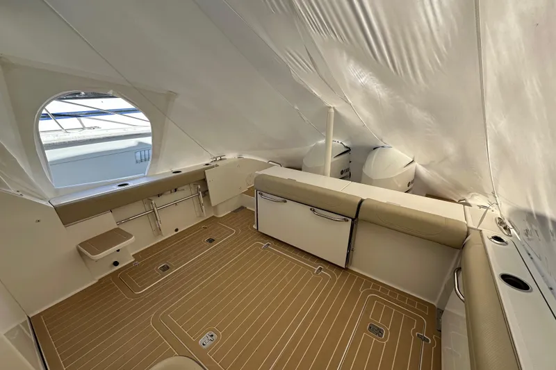 Slide: The Image of 2019 Pursuit DC 325 Dual Console boat interior with covered seating and wood-patterned flooring. - 4