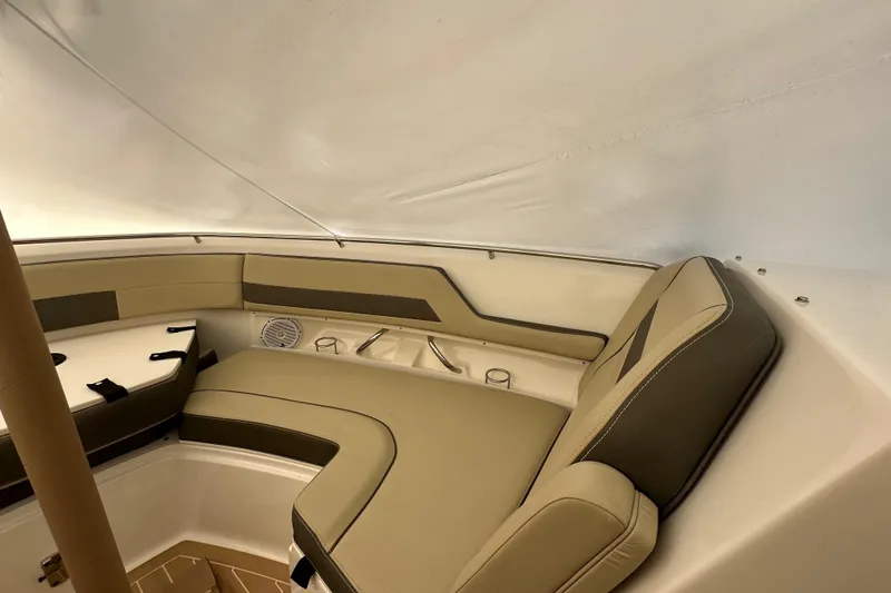Slide: The Image of 2019 Pursuit DC 325 Dual Console interior with beige seating and cup holders. - 45