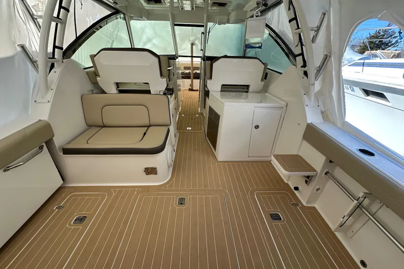 Slide: The Image of 2019 Pursuit DC 325 Dual Console interior with seating, cabinetry, and wood-patterned flooring. - 8